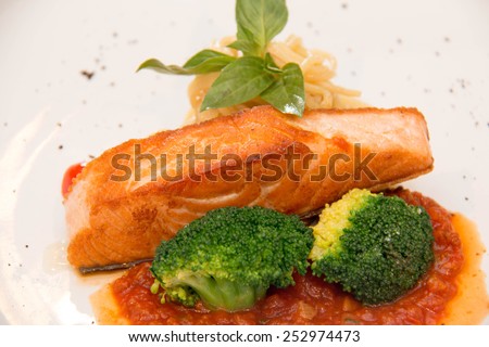 Stake from a salmon with vegetables on a plate. Closeup.