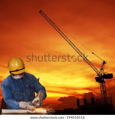 Construction worker cutting metal with a construction background.