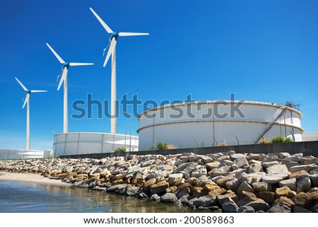 Large natural gas storage tanks with a windmill.
