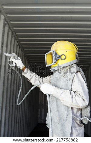 Worker prepare spray painting color inside wall container box steel