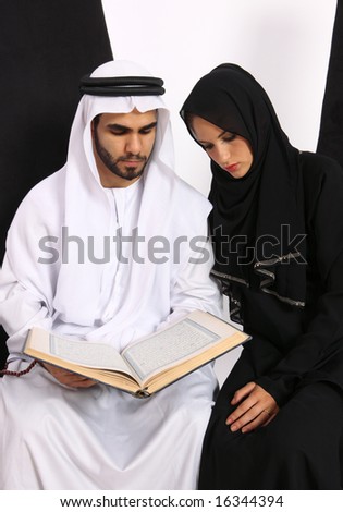 stock photo : Arabic Couple Referring To The Holy Quran