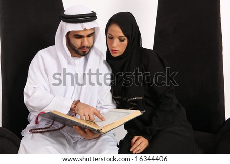 stock photo : Arab Man Reads & Explains Verses From The Quran To His Wife