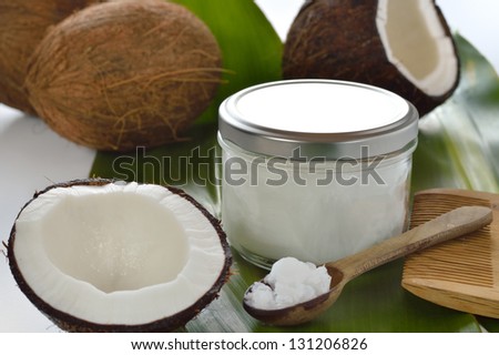Coconuts and organic coconut oil in a glass jar on white background. Hair treatment.