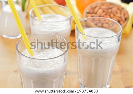 Banana and almond milk smoothie in a glass on a kitchen table. Summer drink made of banana, almond milk