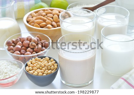 Different vegan milks on a table. Hazelnut, rice, soya and almond milk. Substitute for dairy milk.
