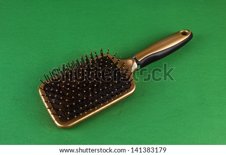 CLOSE-UP OF A HAIRBRUSH WITH LOST HAIR IN IT