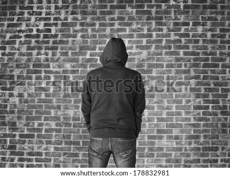 Young man covered his head against wall,black and white
