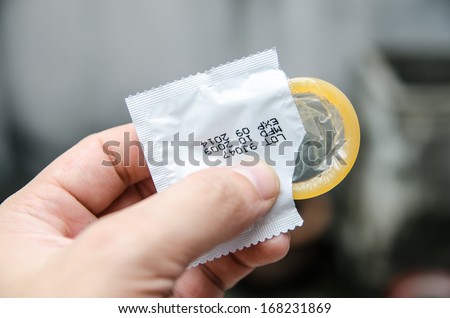 Safe sex concept. Hand with condom