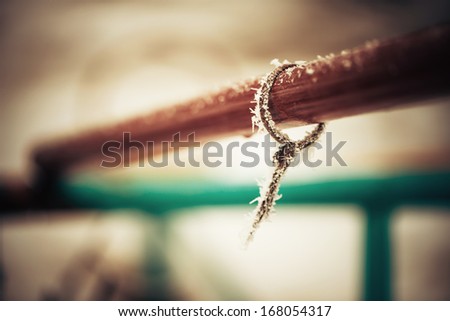 old frozen rope on metallic pipe