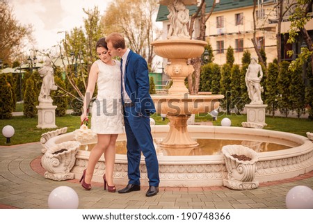 young wedding couple at spring garden fountain