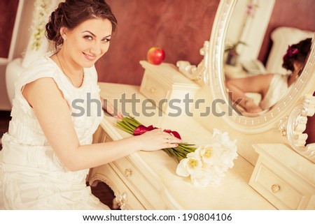 smiling bride at vintage boudoir table with mirror