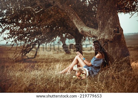 lonely girl under autumn meadow tree