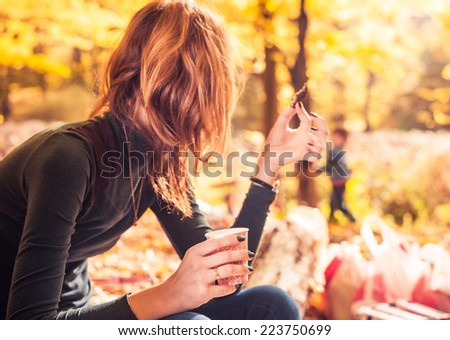 woman at fall season forest picnic looking at playful kid