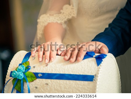 bride and groom arms on a treasure box