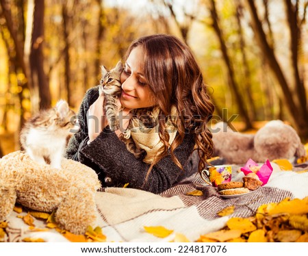 joyful lady with little kitties at autumn forest leafs