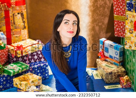 lovely lady in blue dress sitting indoor near holiday presents