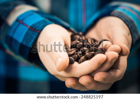 boy holding coffee beans in palms
