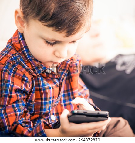 little boy using android touch screen phone