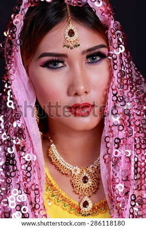 Beautiful young indian woman in traditional clothing with make-up and jewelry.