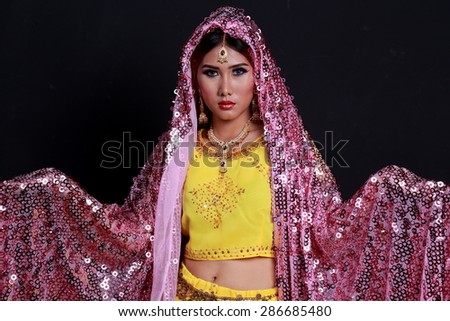 Beautiful young indian woman in traditional clothing with make-up and jewelry.