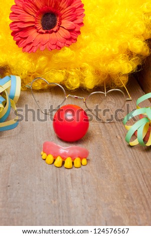 Clowns costume with rotten teeth laying on a wooden board