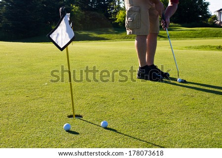 Golfer practicing putting golf balls