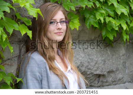 Portrait of a student against an ivy-covered building on campus