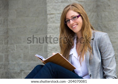 Confident young woman reading her journal