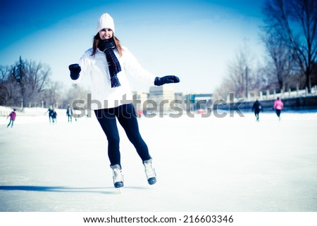 Attractive young woman ice skating during winter