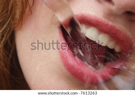 Water pouring in a girl\'s mouth.