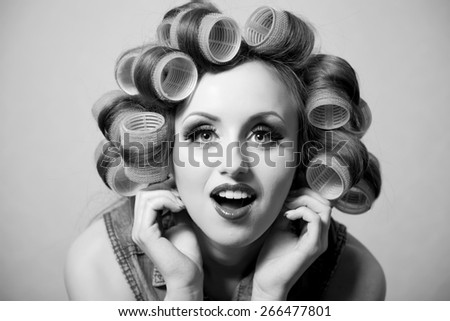 Funny girl with hair curlers on her head on black and white