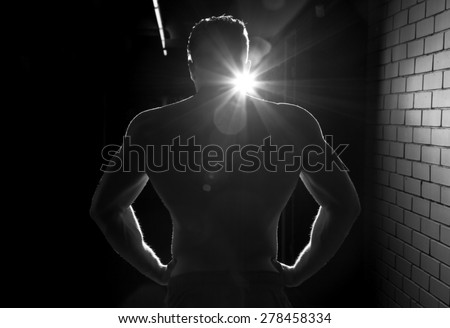 Beautiful and muscular black man's back in dark background