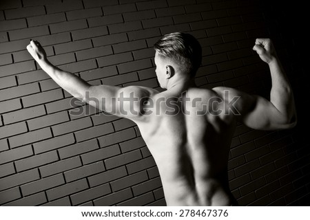 Beautiful and muscular black man's back in dark background