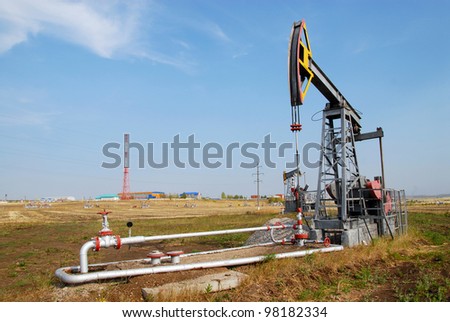 a single oil derrick in the summer on the field