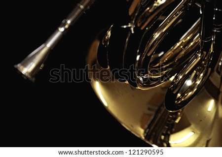 golden shiny french horn closeup on black background, musical instrument