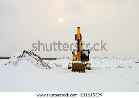 Excavator in the snow field