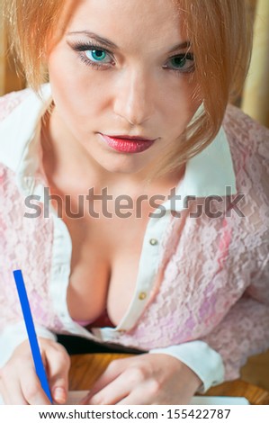 Portrait of a very busy young blond student with blue pencil.