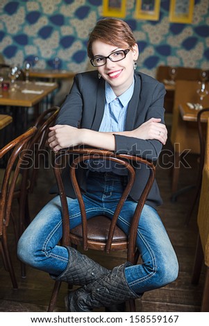 Brunet girl is sitting in interior of Moscow restaurant \