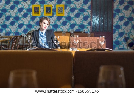 Brunet girl is sitting in interior of Moscow restaurant 