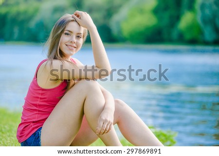 Lady in red T-Shirt is posing in city park near Moscow river