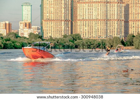 MOSCOW - 28 JULY 2015: Young people company on the orange jacht are surfing at Strogino bay on July 28, 2015 in Moscow