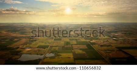 Sunrise on Horizon - illustrated sunrise over an aerial view of South Dakota farm land