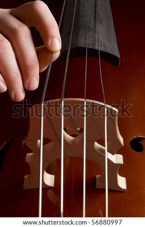 close up of a childhand is playing the cello