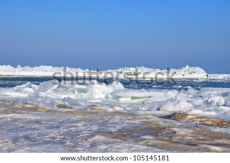 Pierce frozen in ice at sea and blue sky