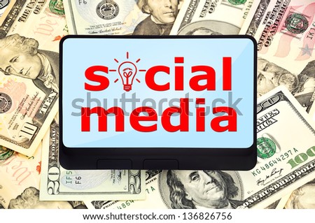 digital tablet with social media on background of dollars