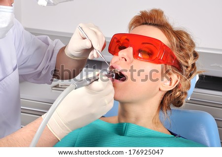 Young girl with red glasses in dentist office chair