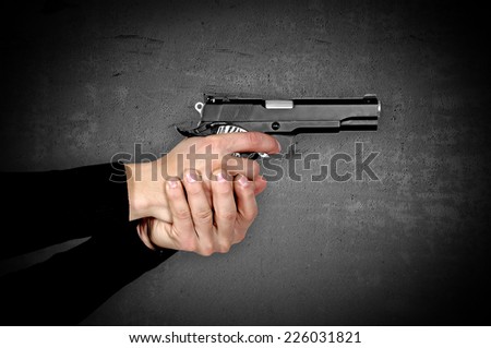 gun in hands on a black background