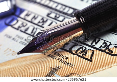 metal nib pen and dollar bill, close up