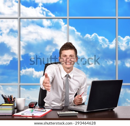 businessman sitting in office and reaches out