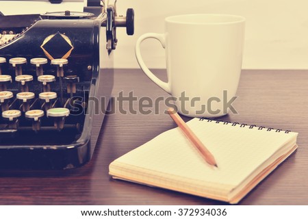 blank notebook, cup and  vintage typewriter  on the writer's desk